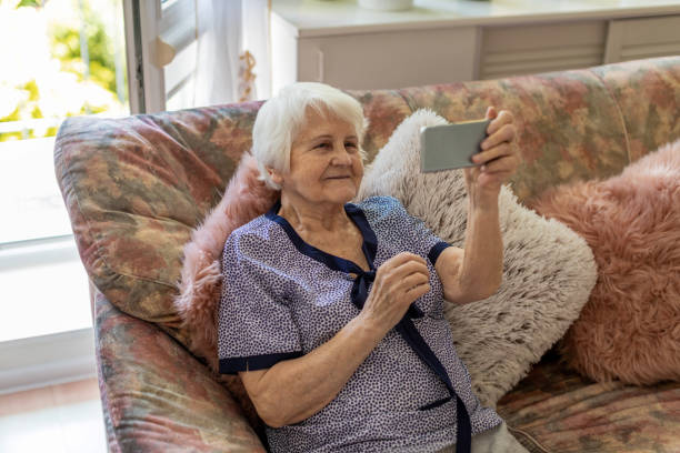 istock Senior woman using mobile phone at home 1248780063