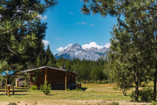 istock Cabin in pine forest with mountains in the background and sky with clouds 1248780093