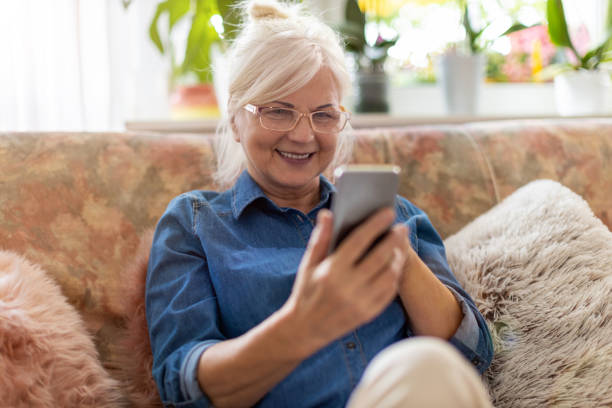 istock Senior woman using mobile phone at home 1248780147