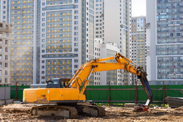 istock Heavy excavator in a working high frequency hydraulic vibratory mounted pile driver on road against the background of residential multi-storey buildings. 1248781252