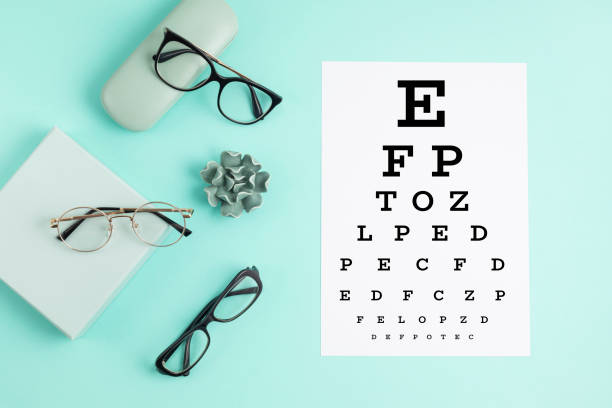 istock Collection of eyeglasses with eye test table. Optical store, glasses selection, eye test, vision examination at optician, fashion accessories concept. Top view 1248782291