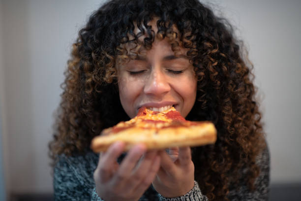 czarna kobieta jedząca pizzę sama - eating food biting pizza zdjęcia i obrazy z banku zdjęć