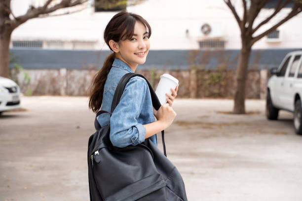 コーヒーとバックパックを持つ若いアジアの女性学生の肖像画