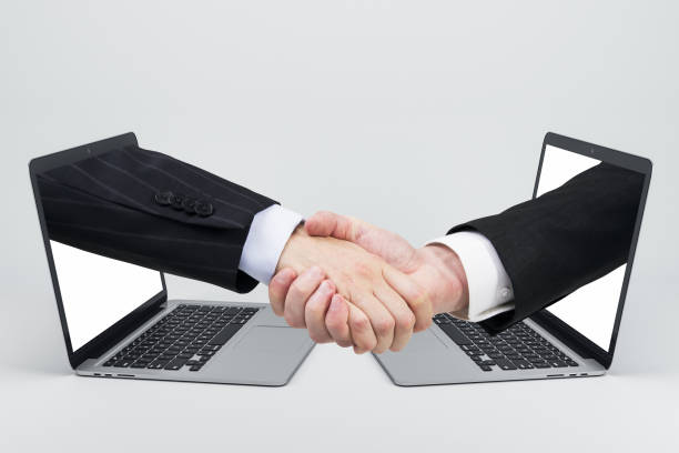 istock Businessmen shaking hands through laptop screens 1248784923