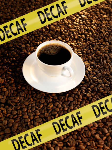 Decaf coffee Cup fo decaf black coffee on top of roasted coffee beans with yellow warning tape decaffeinated stock pictures, royalty-free photos & images