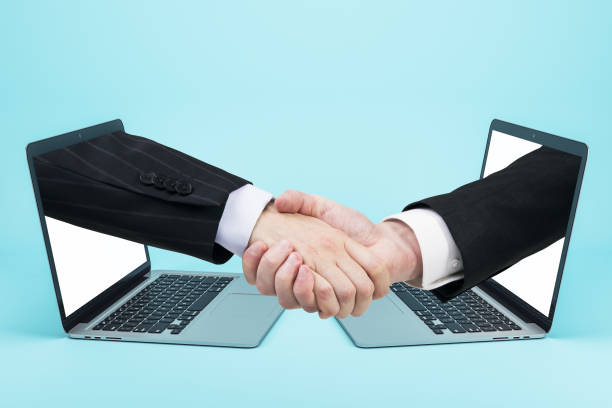 istock Businessmen shaking hands through laptop screens 1248786762