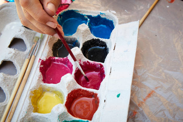 istock Natural paints with brush and hand selective focus 1248786927