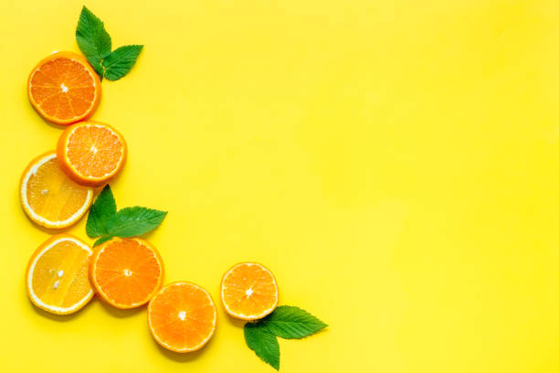 istock Orange slices with leaves on yellow top view 1248787944