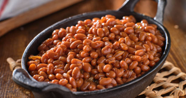 baked beans in cast iron skillet baked beans in cast iron skillet shot with selective focus baked beans stock pictures, royalty-free photos & images