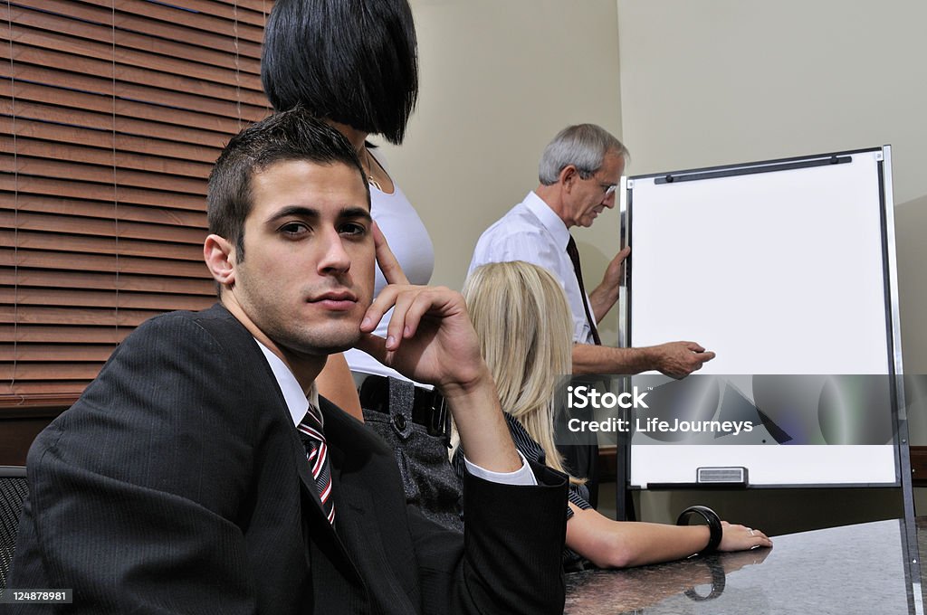 Jump Starting Your Career Man Facing Camera While Rest Of Team Are Watching A Business Manager Explain Points and Procedures.Shallow Depth OF Field.  Space For Copy. Adult Stock Photo
