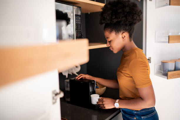 Woman preparing a fresh coffee with a coffee maker machine