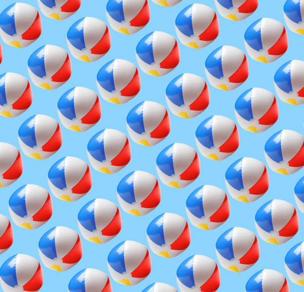A field of classic beach balls isolated on a blue background.