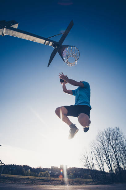 istock Man jumping and making a fantastic slam dunk 1248801737