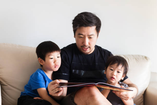 istock Small family engaged in read aloud book together 1248803218