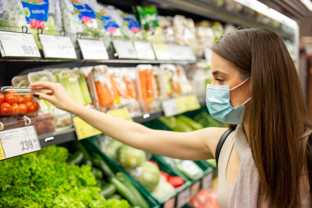 istock Young woman is picking up vegetables in grocery store 1248804329