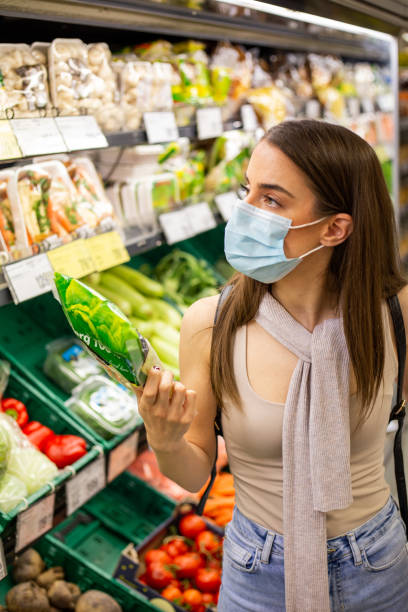 istock Young woman is picking up vegetables in grocery store 1248804364