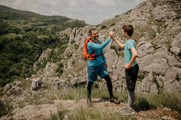 istock Father with son enjoying success on rocky mountain 1248804789