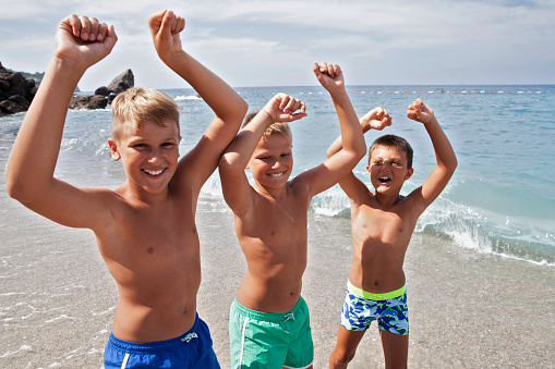 three boys having fun at the beach