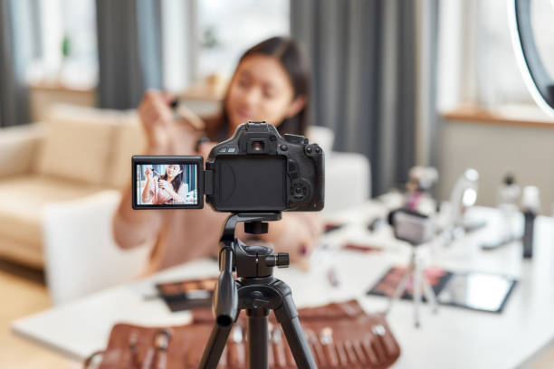 istock New perspectives. Asian female blogger showing cosmetic products while recording a tutorial video for her beauty blog using camera at home 1248805540