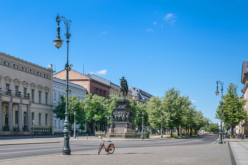 Unter den Linden boulevard in the central Mitte district of Berlin with the equestrian statue of King Frederick II of Prussia and  linden trees  lining the pedestrian mall on the median and the two carriageways