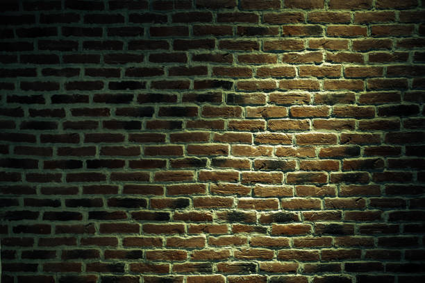 istock Urban texture of a brick wall with a light spot. 1248812012