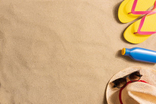 istock Summer vacation composition. Sun cream, flip flops and straw hat on sand 1248815276