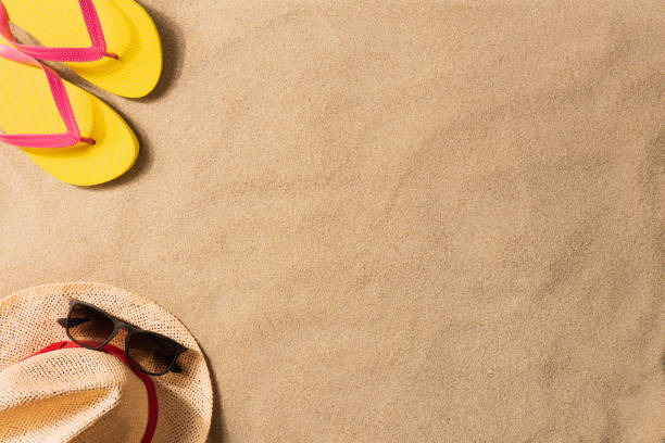 istock Summer vacation composition. Flip flops and straw hat on sand 1248815283