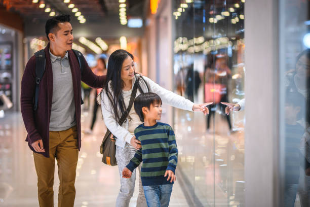 chinese mother showing son retail display at hong kong mall - harbour city imagens e fotografias de stock