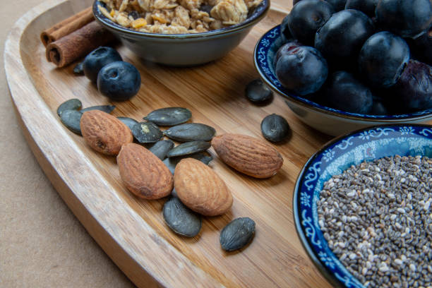 gesunde und biologische heidelbeeren und samen. - almond variation bamboo bowl stock-fotos und bilder