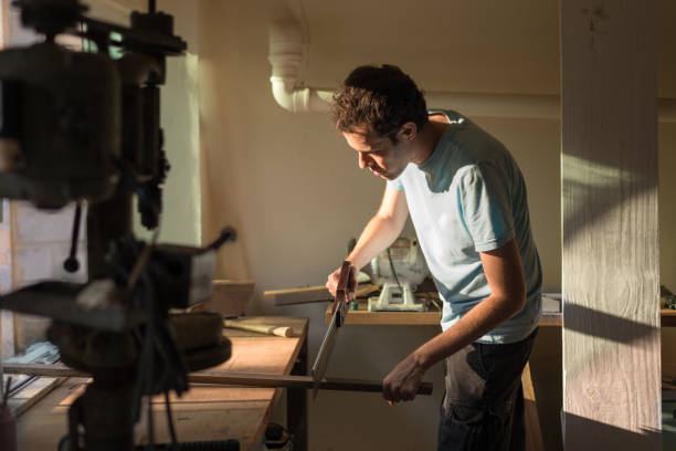 istock Man cutting wood with a saw on workshop 1248828225
