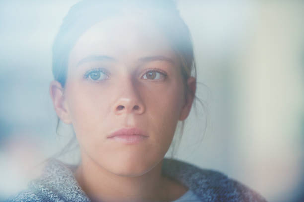 retrato de una mujer sentada mirando a través de la ventana. - teenager adolescence portrait pensive fotografías e imágenes de stock