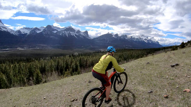 istock Female mountain biker rides e-bike along mountain ridge 1248833472