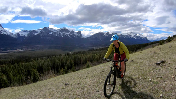 istock Female mountain biker rides e-bike along mountain ridge 1248833505