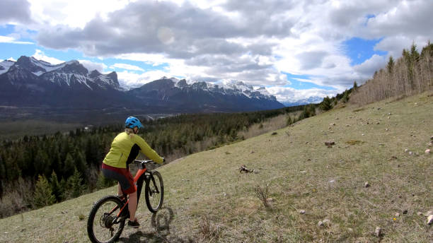 istock Female mountain biker rides e-bike along mountain ridge 1248834218