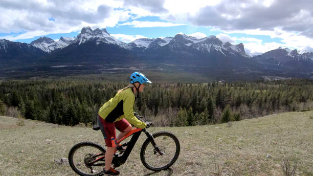 istock Female mountain biker rides e-bike along mountain ridge 1248834312