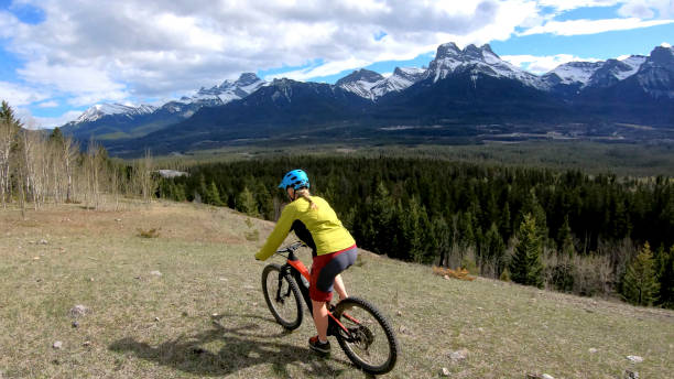 istock Female mountain biker rides e-bike along mountain ridge 1248834403