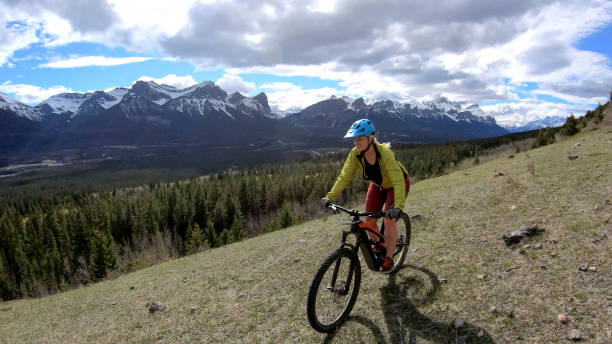 istock Female mountain biker rides e-bike along mountain ridge 1248835581