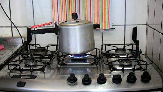 salvador, bahia / brazil - june 10, 2020: Pressure cooker is seen on a stove in a kitchen in the city of Salvador.