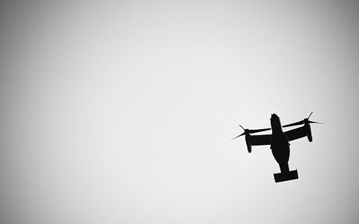 A silhouette of a tilt-rotor military aircraft, from below.