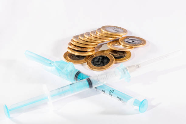 istock syringes and brazilian real coins in white background 1248848995