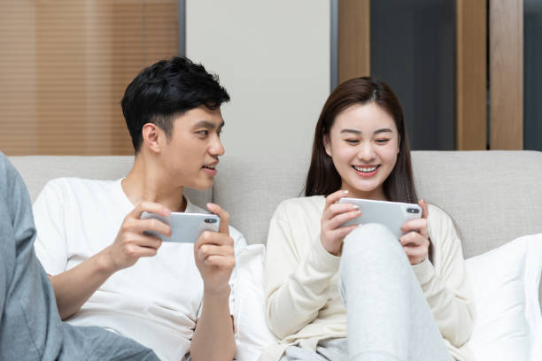 istock A young Asian couple is playing mobile phone in bed 1248850680