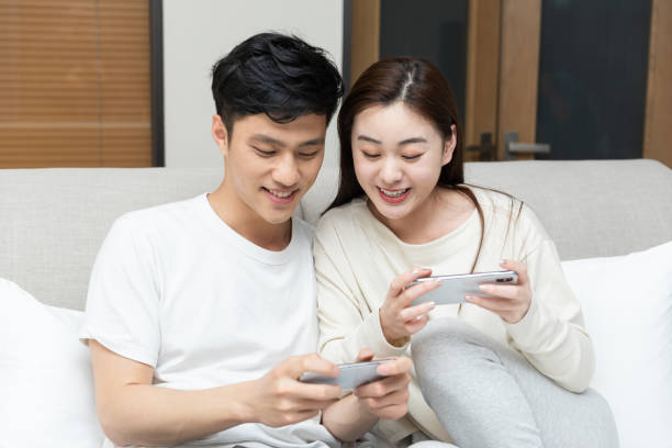 istock A young Asian couple is playing mobile phone in bed 1248850690