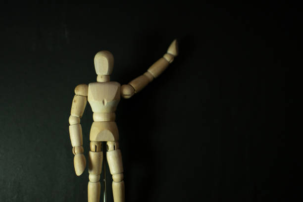 istock wooden mannequin chasing pointing up on black background 1248853440