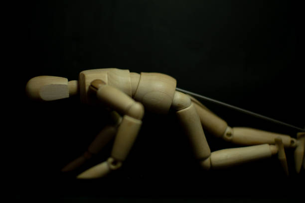 istock wooden mannequin clawing floor pose on black background 1248854041