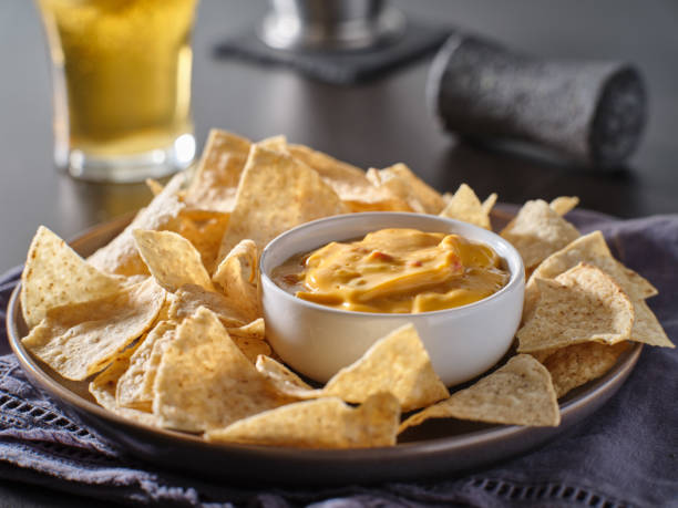 mexican hot queso cheese dip with corn tortilla chips on plate mexican hot queso cheese dip with corn tortilla chips on plate close up cheese dip stock pictures, royalty-free photos & images