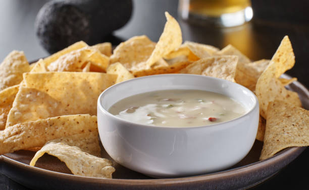 mexican hot queso blanco cheese dip with corn tortilla chips mexican hot queso blanco cheese dip with corn tortilla chips on plate nacho chip photos stock pictures, royalty-free photos & images