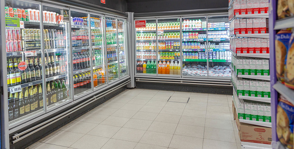 Refrigerators line full of food in an  empty supermarket place