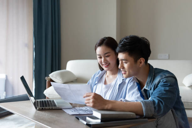 istock A young asian couple is sitting on a carpet using a computer 1248865786