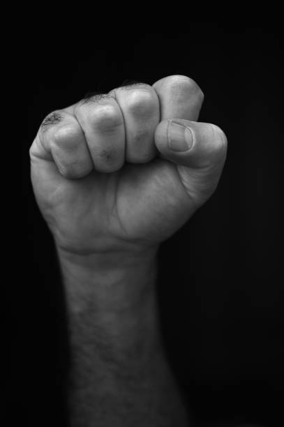 istock Male raised fist isolated on black background 1248871188