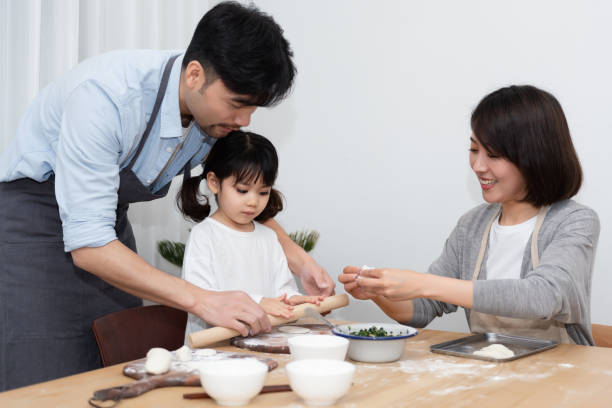 istock Young Asian mom and dad making dumplings with daughter 1248875393